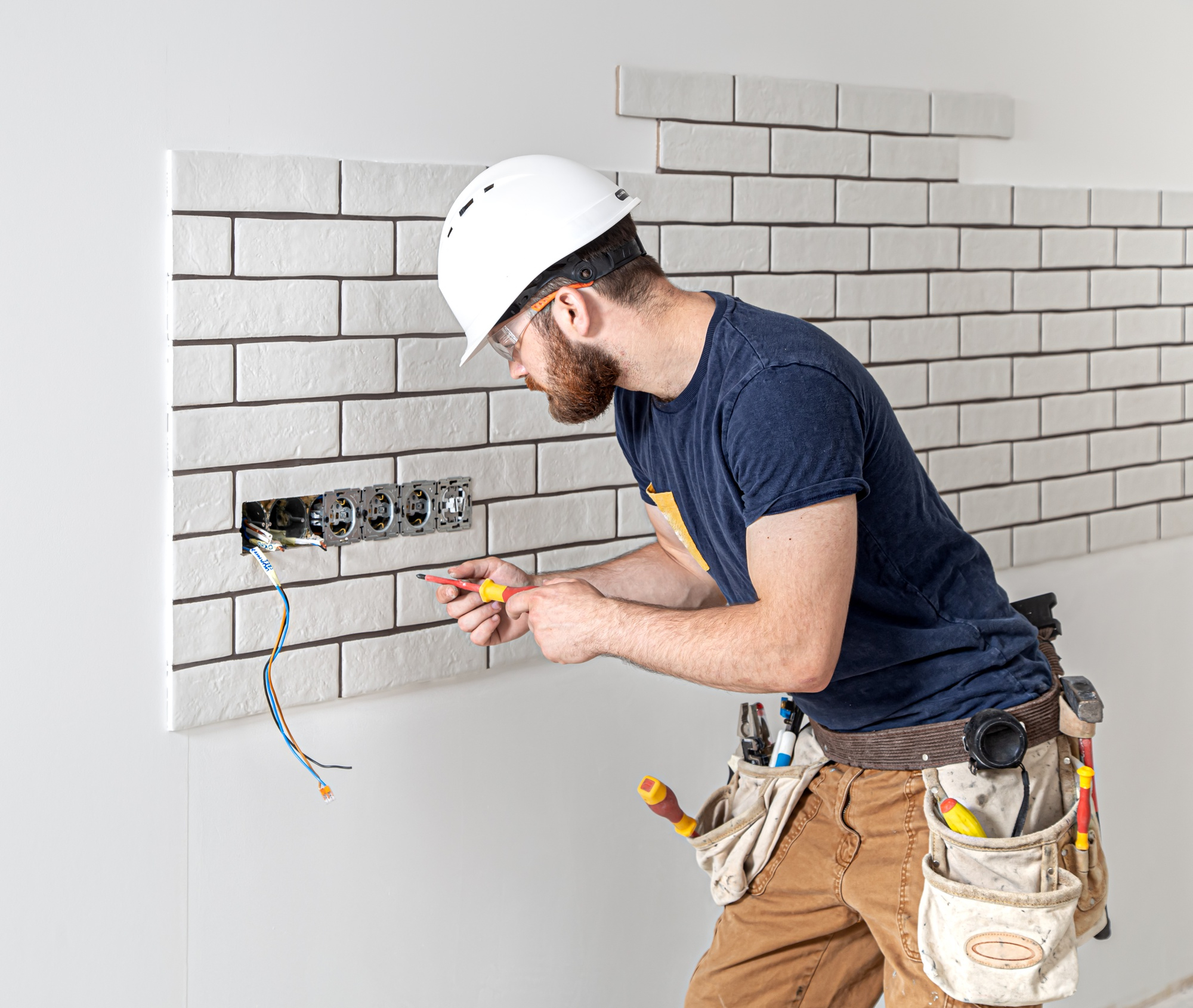 electrician-construction-worker-with-beard-overalls-during-installation-sockets-home-renovation-concept