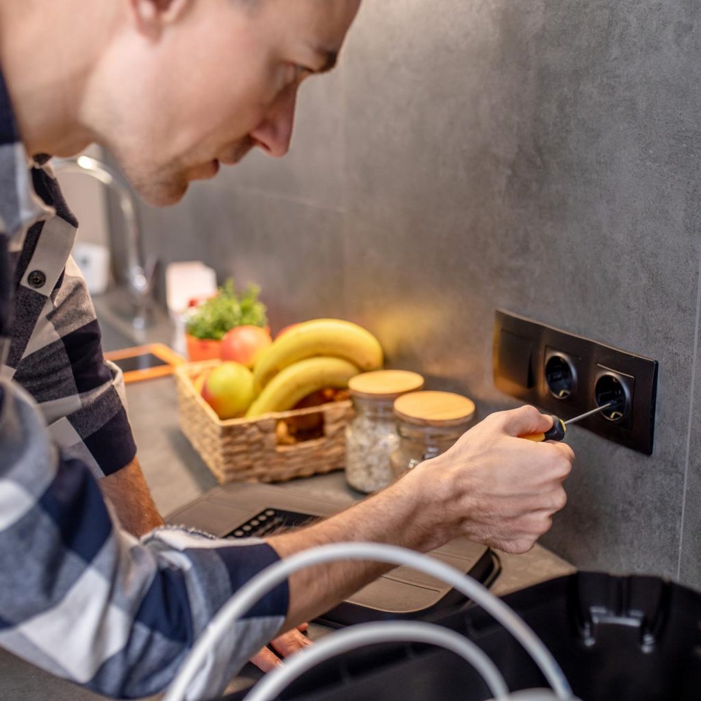 power-socket-closeup-photo-man-touching-black-socket-kitchen-wall-with-special-screwdriver